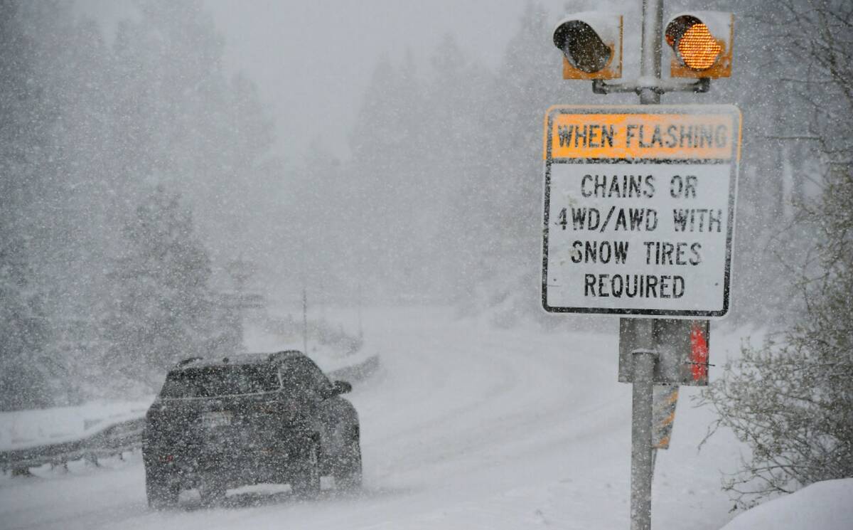 A car passes a caution sign as heavy snow falls on the Mt. Rose Highway near Reno, Nev., on Dec ...