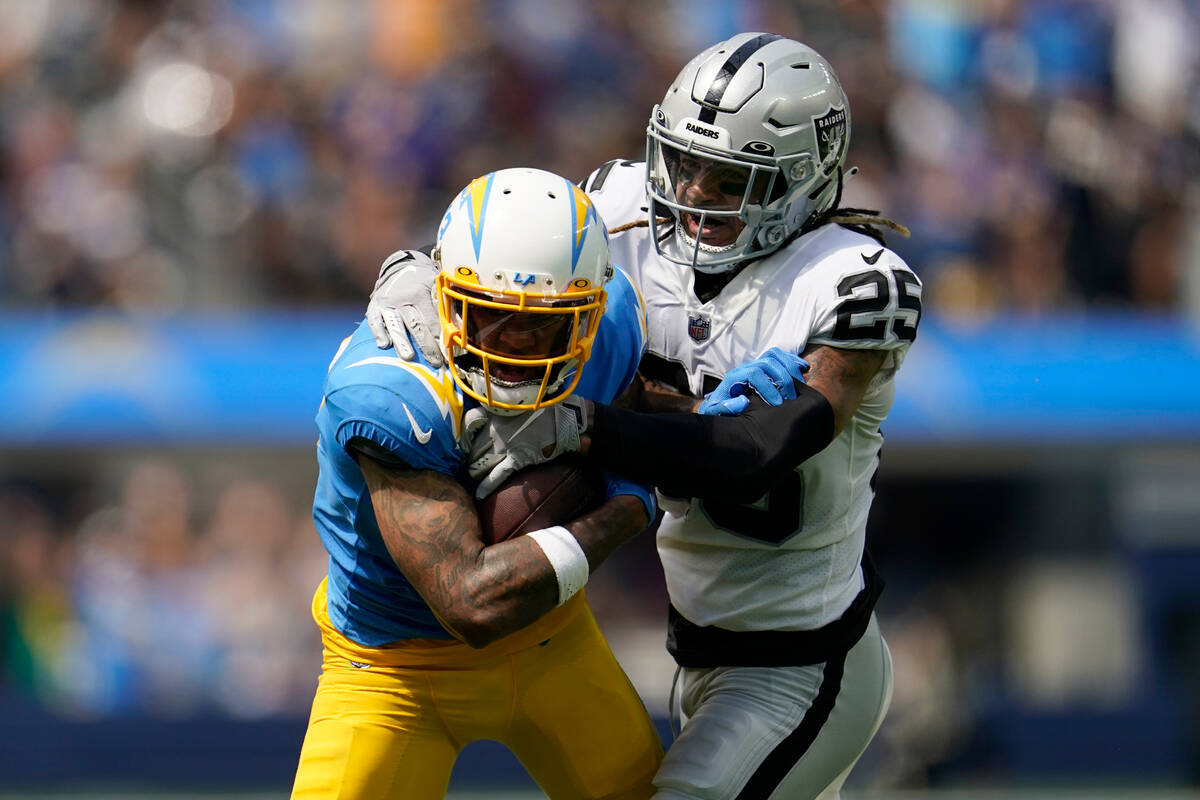 Los Angeles Chargers wide receiver Keenan Allen, left, runs against Las Vegas Raiders safety Tr ...