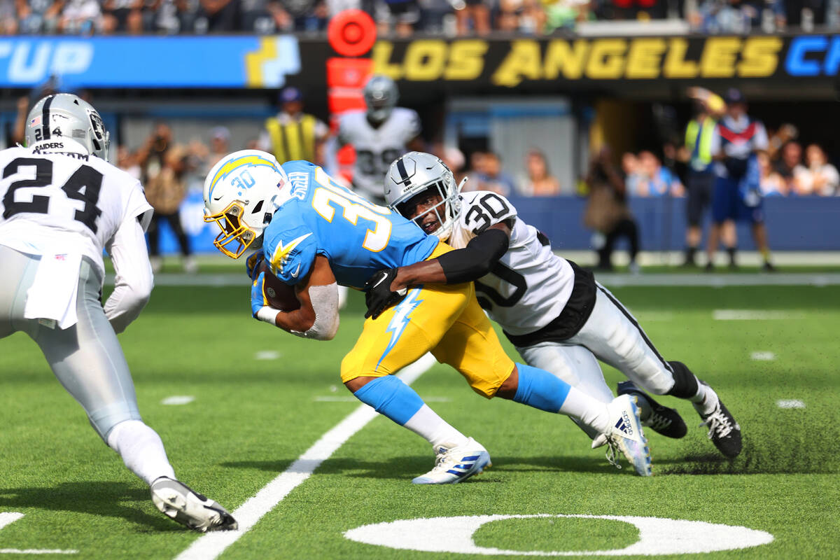 Raiders safety Duron Harmon (30) tackles Los Angeles Chargers running back Austin Ekeler (30) d ...
