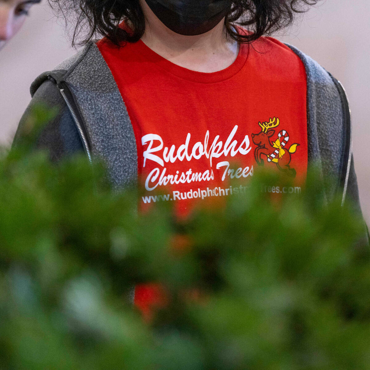 Dylan Zaudke wears a company T-shirt while trimming a tree for purchase at Rudolph's Christmas ...