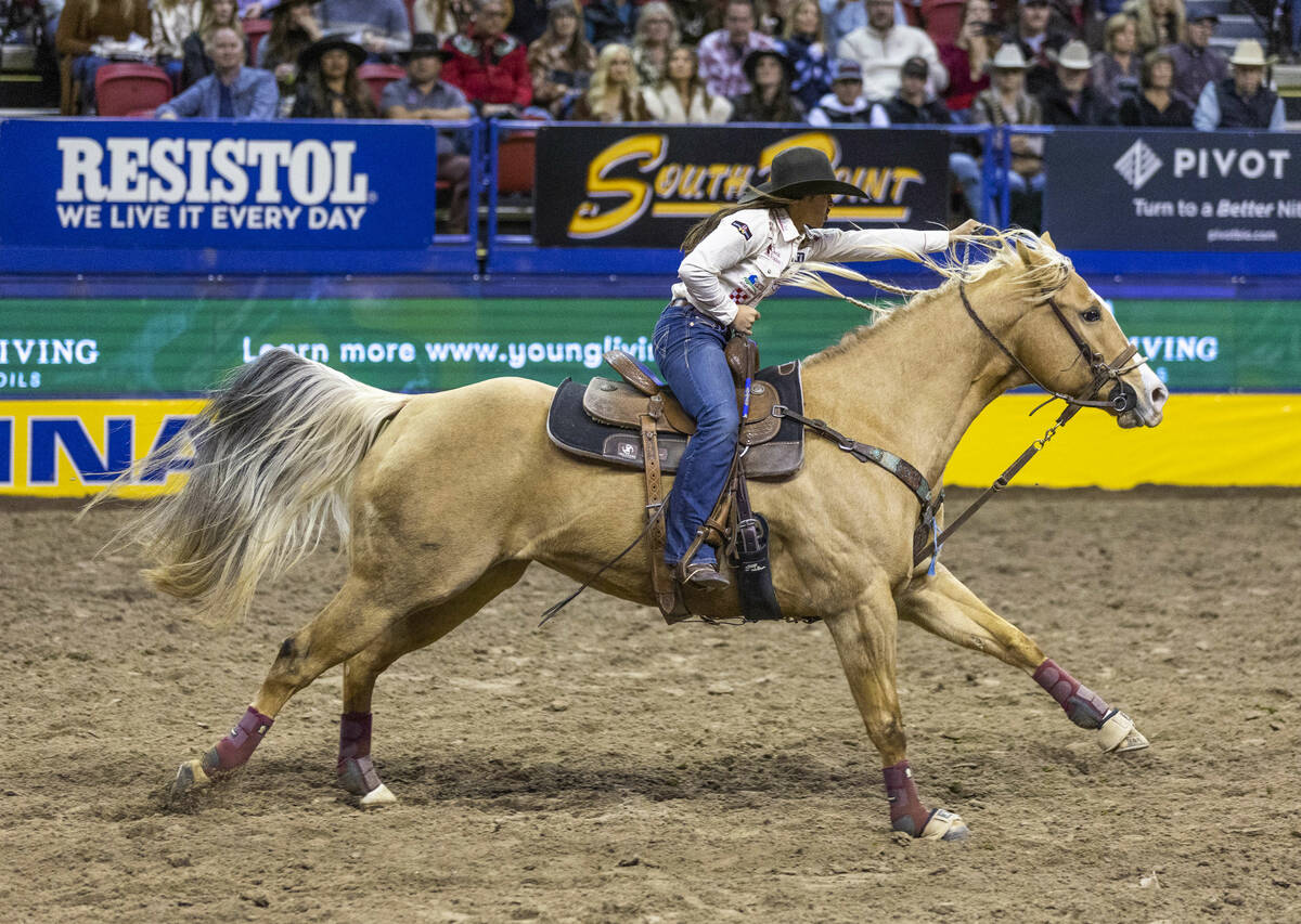 Hailey Kinsel of Cotulla, Texas, runs full out for the final barrel on her winning time during ...