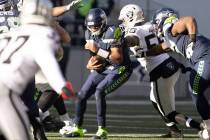 Raiders defensive end Chandler Jones (55) wraps up Seattle Seahawks quarterback Geno Smith (7) ...
