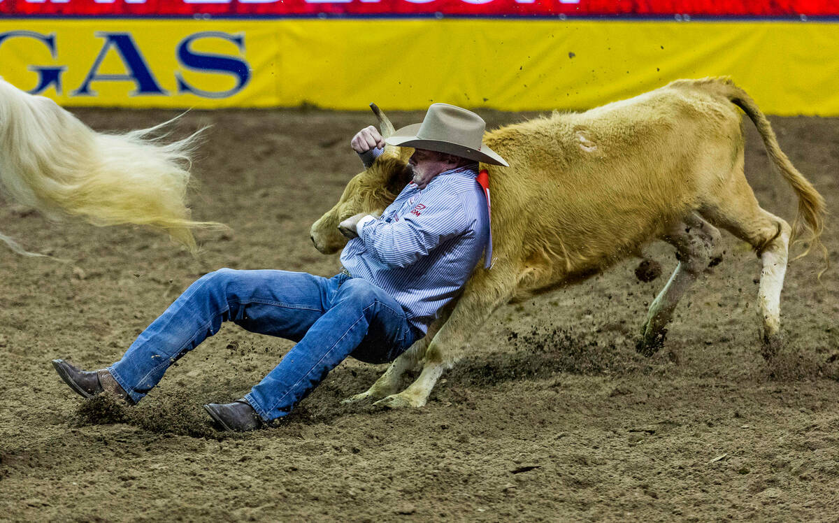 Hunter Cure of Holliday, TX., competes in Steer Wrestling on his winning round during the Natio ...