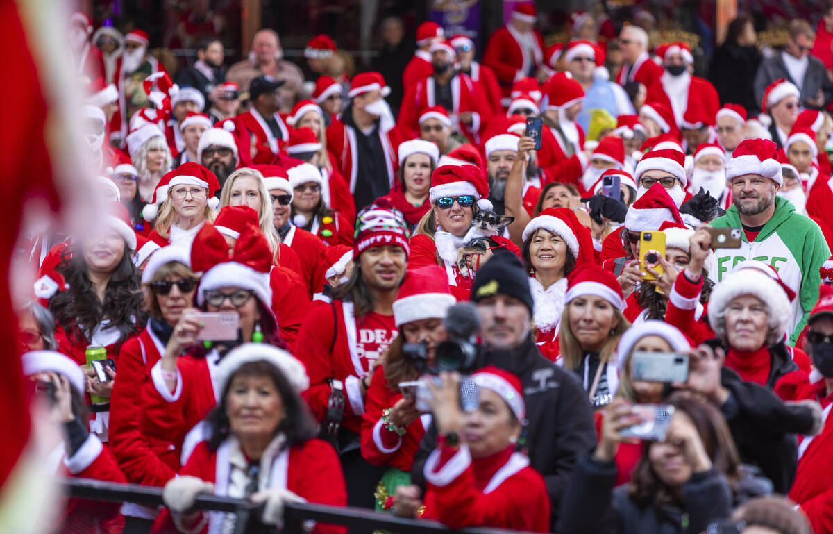 Participants clad in Santa outfits enjoy some of the pre-race entertainment at the Fremont Stre ...