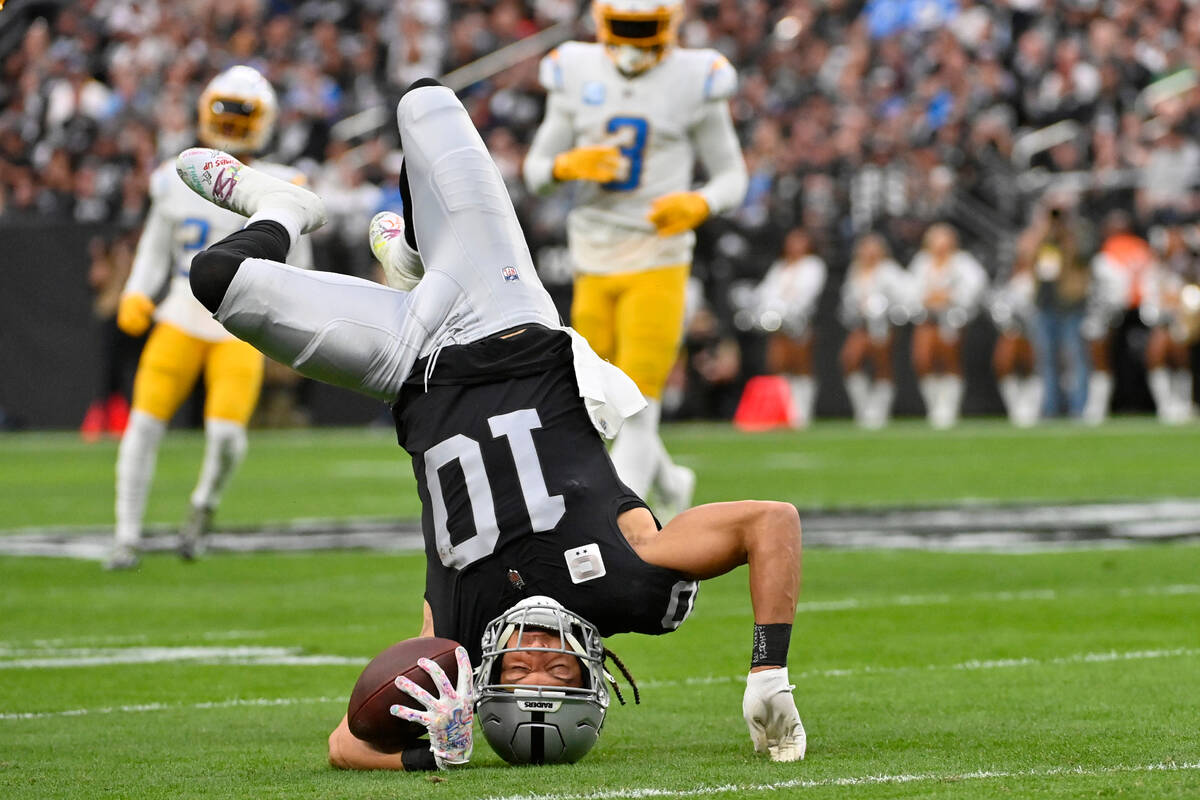 Las Vegas Raiders wide receiver Mack Hollins (10) goes upside down on a reception during the fi ...