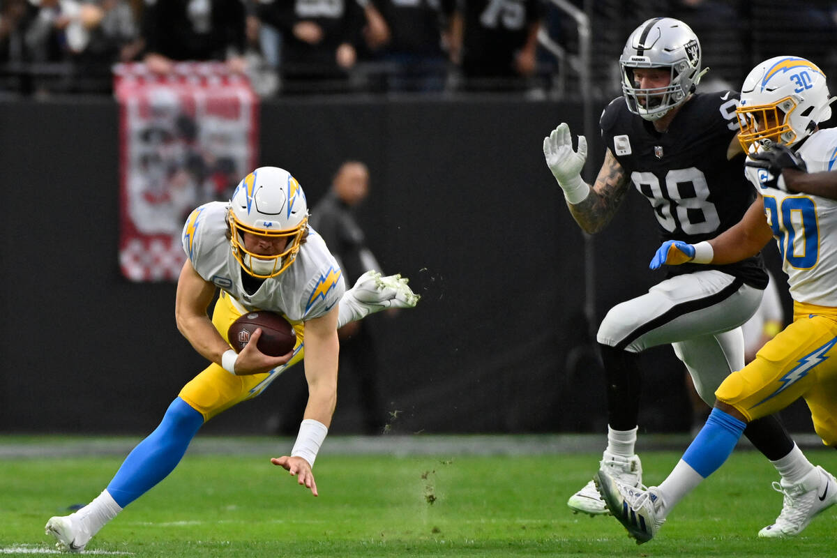 Los Angeles Chargers quarterback Justin Herbert (10) carries after picking up his fumble under ...