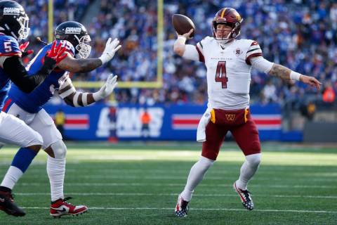 Washington Commanders quarterback Taylor Heinicke, right, throws during the first half of an NF ...