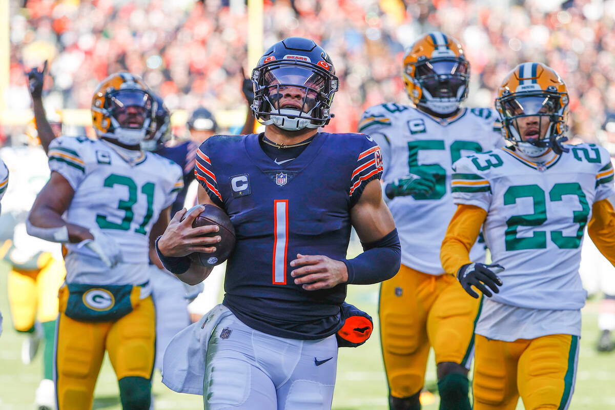 Chicago Bears quarterback Justin Fields (1) scores a touchdown against the Green Bay Packers du ...