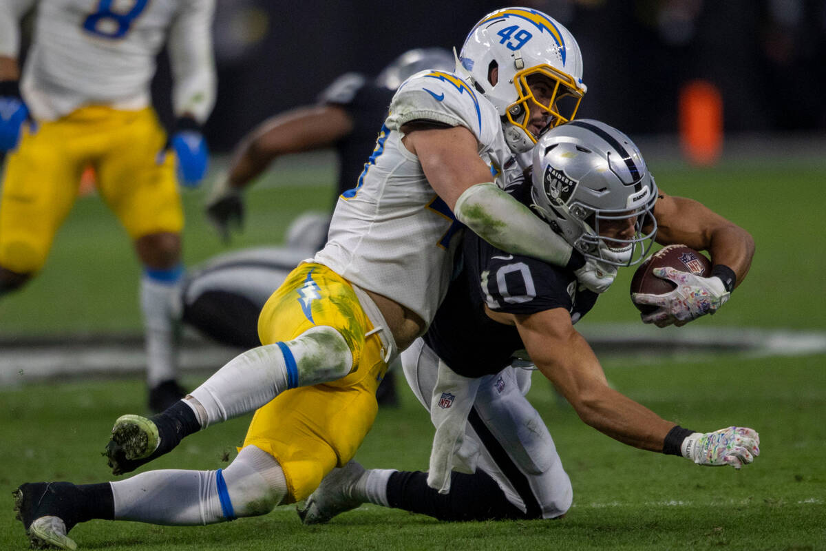 Los Angeles Chargers linebacker Drue Tranquill (49) tackles Raiders wide receiver Mack Hollins ...