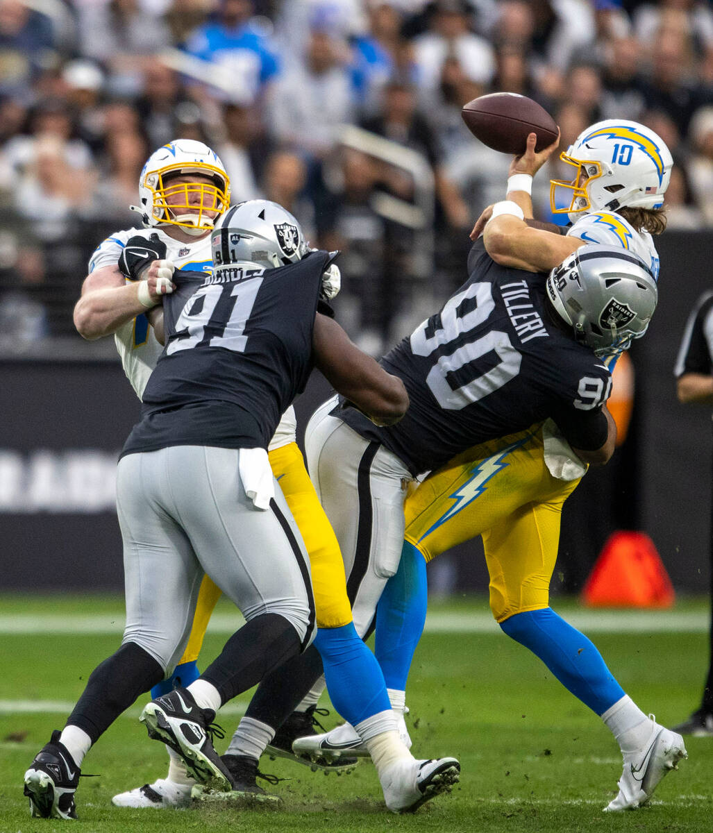 Raiders defensive tackle Jerry Tillery (90) hits Los Angeles Chargers quarterback Justin Herber ...