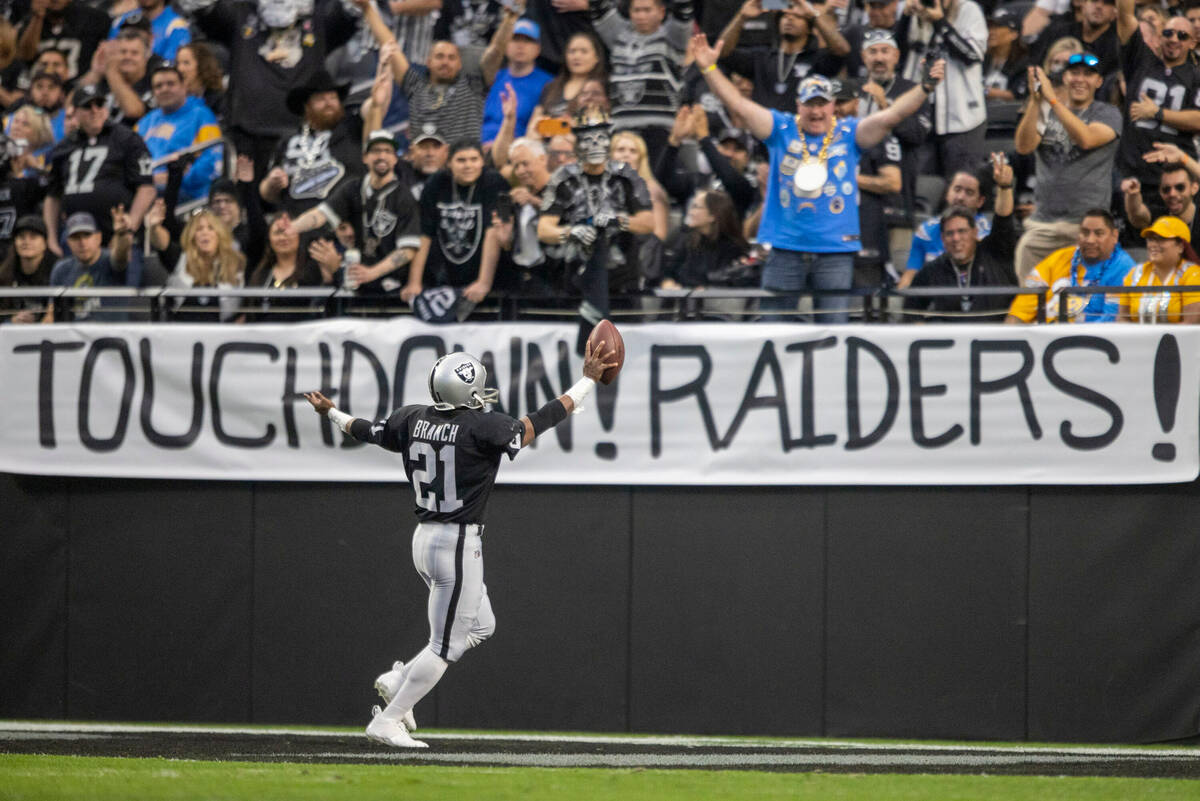 A player dressed as Raiders Hall of Fame wide receiver Cliff Branch scores near signage that re ...