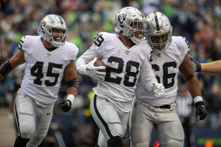 Raiders running back Josh Jacobs (28) celebrates his touchdown with offensive lineman Dylan Par ...