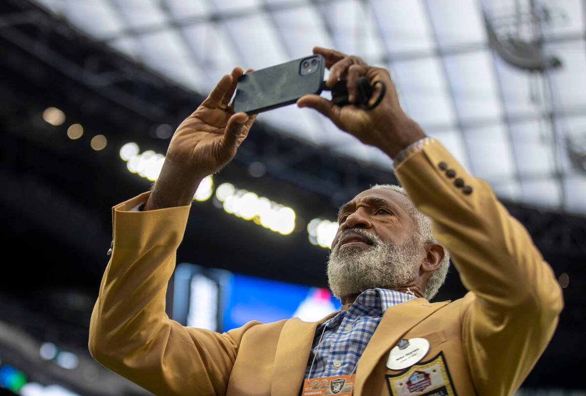 Raiders Hall of Fame cornerback Mike Haynes takes photos before an NFL game between the Raiders ...