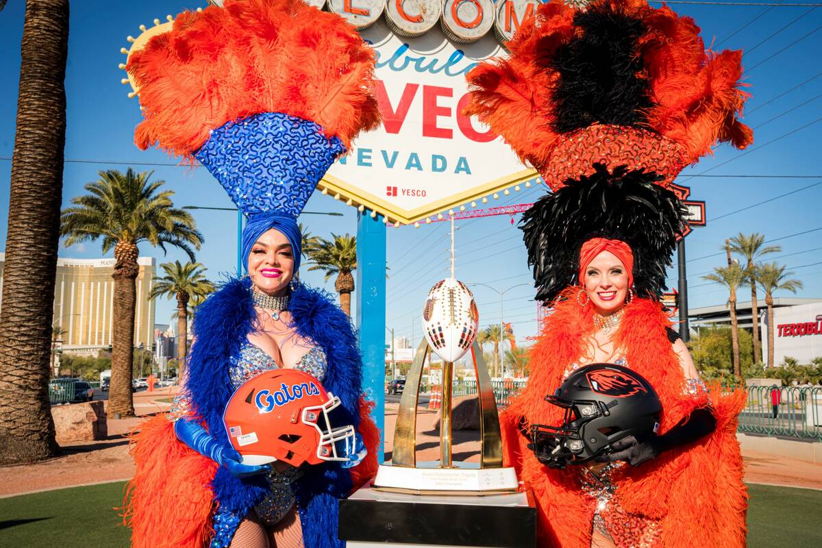 Showgirls display the helmets for Las Vegas Bowl participants Florida, left, and Oregon State o ...