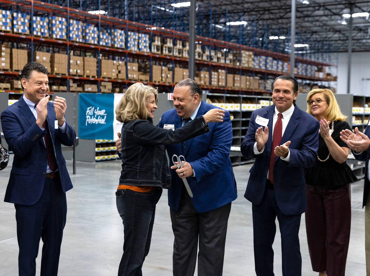 Henderson Mayor Debra March hugs Marcelo Fioranelli, chief executive officer at Airgas, center, ...