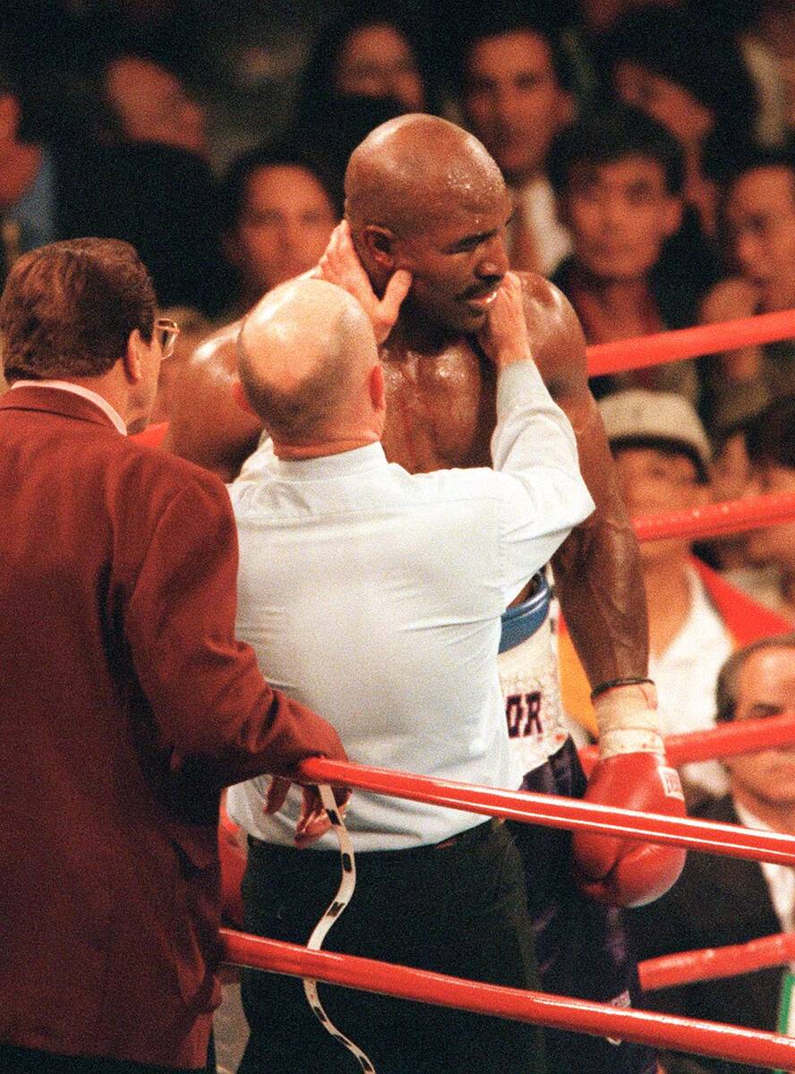 Referee Mills Lane checks out the ear of boxer Evander Holyfield after opponent Mike Tyson bit ...