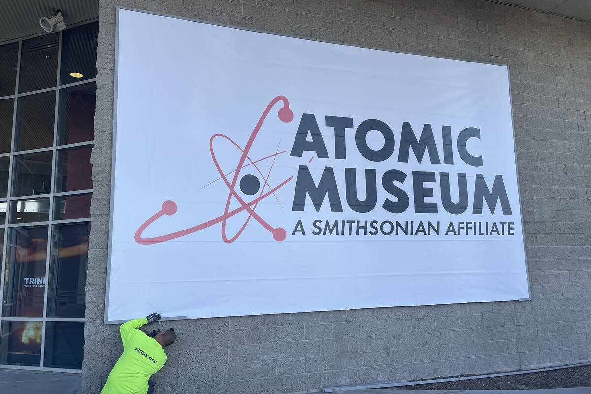 A worker installs a new sign to signal the renaming of the Atomic Museum in Las Vegas. (Atomic ...