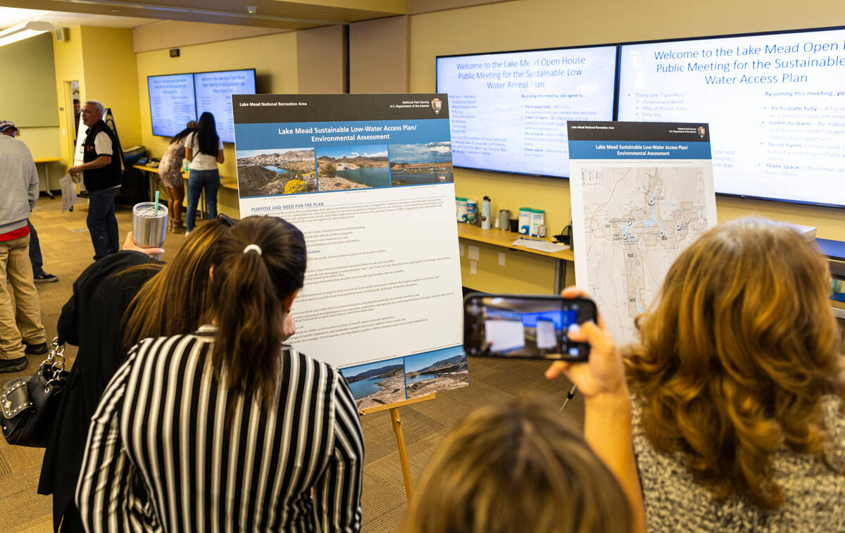 Attendees read informational boards during an open house public meeting for the Sustainable Low ...