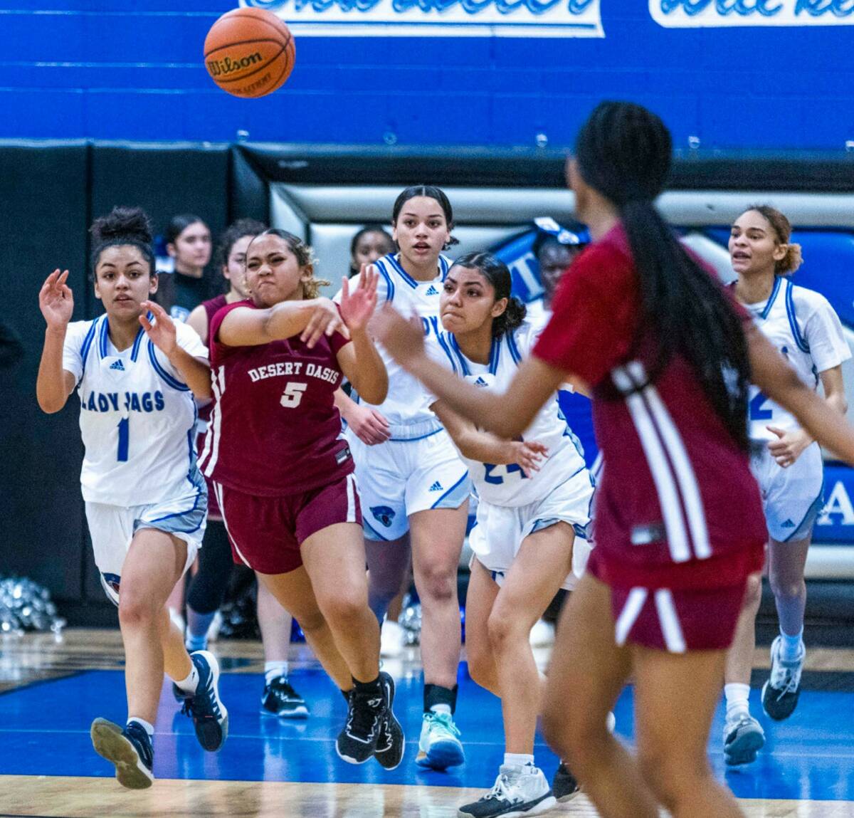 Desert Oasis guard Savanna Sadler (5) fires a pass up the court between Desert Pines guard Mia ...