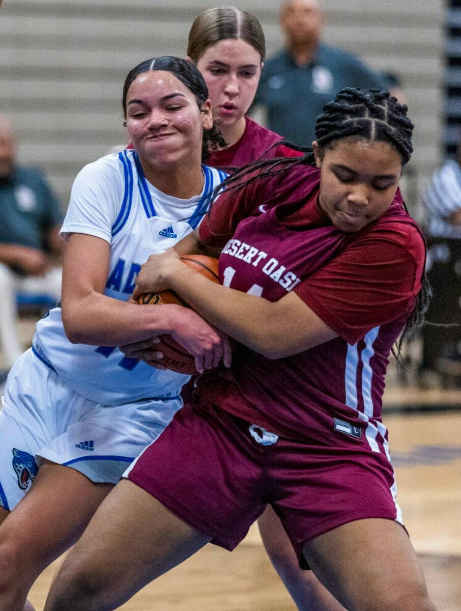 Desert Pines center Alanna Jackson (11) fights for a ball with Desert Oasis guard Kohen Marshal ...