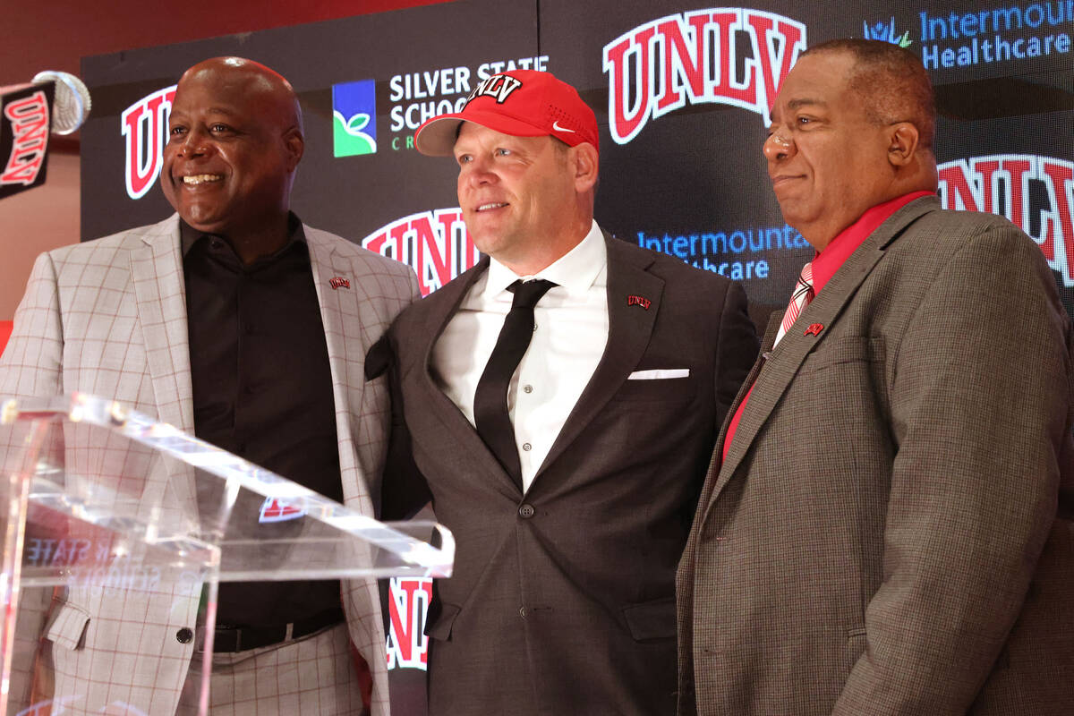 New UNLV football coach Barry Odom is introduced with Athletic Director Erick Harper, left, and ...