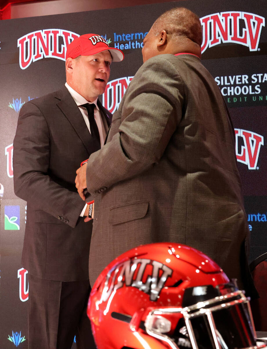 New UNLV football coach Barry Odom, left, greets President Keith Whitfield before being introdu ...