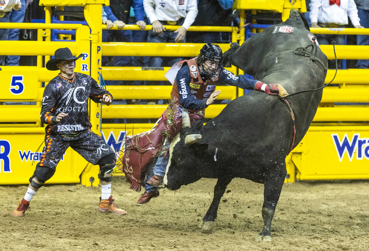 Josh Frost of Randlett, Utah, is unable to release from the bull and is spun around in Bull Rid ...