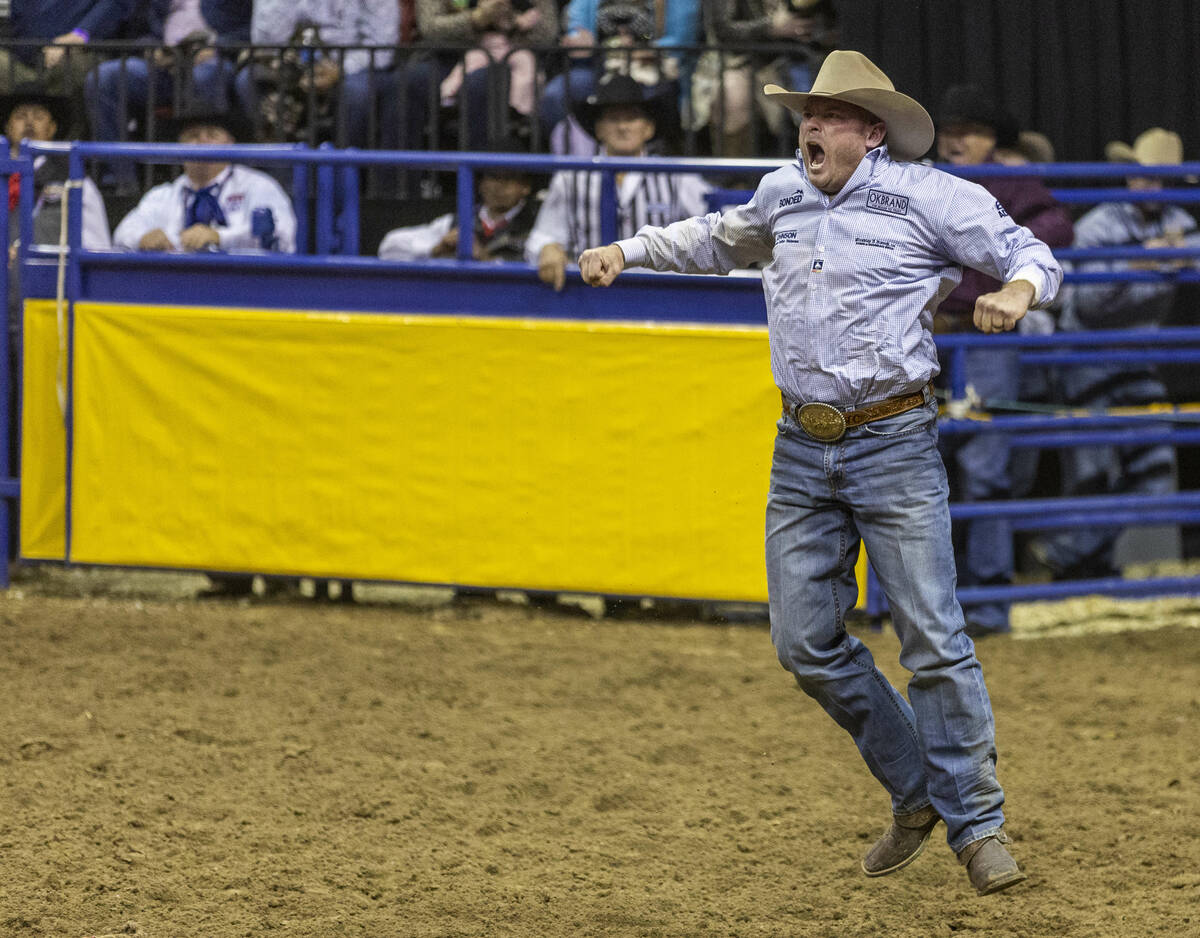 Hunter Cure of Holliday, Texas, celebrates a winning time in Steer Wrestling during the Nationa ...