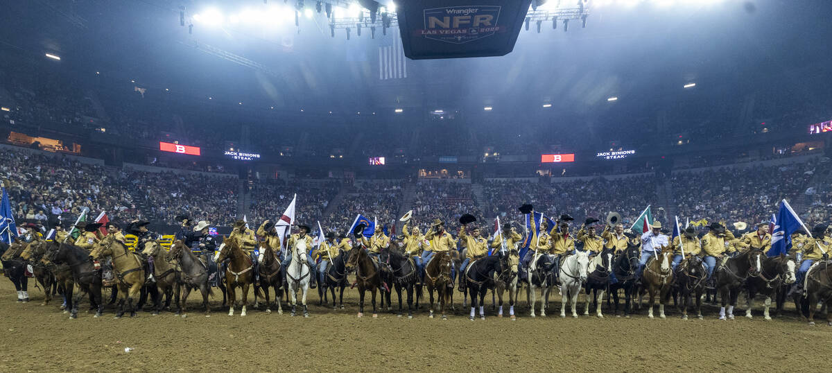 Competitors tip their hats to the crowd after being introduced during the National Finals Rodeo ...