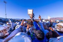 Bishop Gorman head coach Brent Browner presents the winning trophy to his players after defeati ...