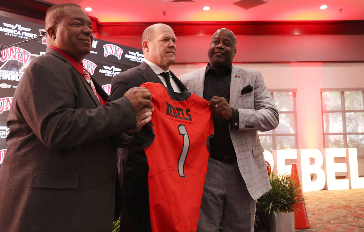 New UNLV football coach Barry Odom is introduced with Athletic Director Erick Harper, left, and ...