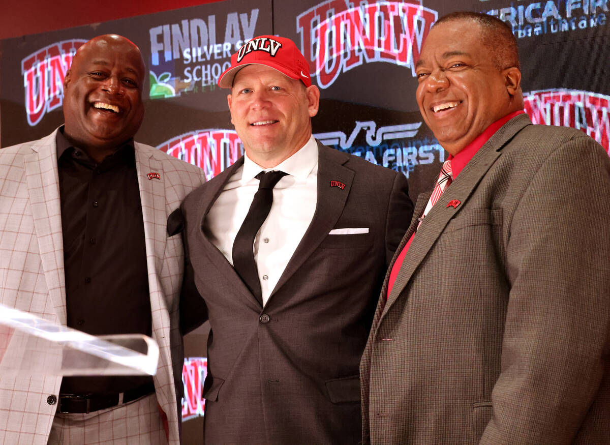 New UNLV football coach Barry Odom is introduced with Athletic Director Erick Harper, left, and ...