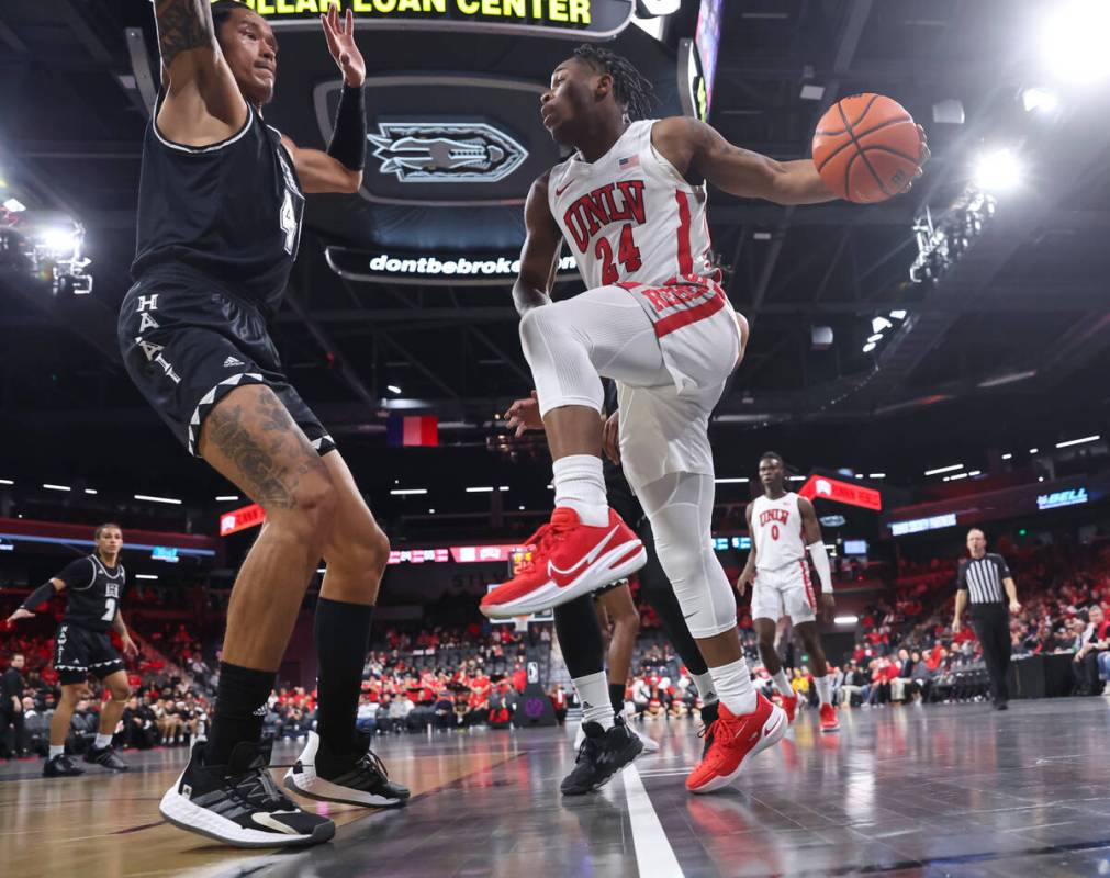 UNLV Rebels guard Jackie Johnson III (24) looks to pass the ball around Hawaii Warriors forward ...