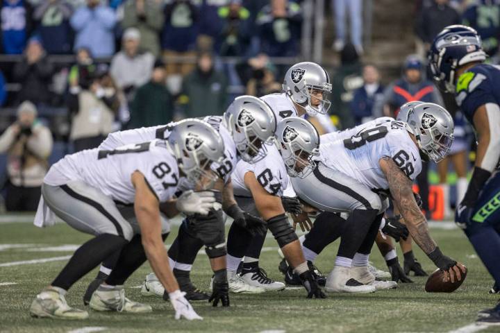 Raiders quarterback Derek Carr (4) lines up behind center Andre James (68) during overtime of a ...