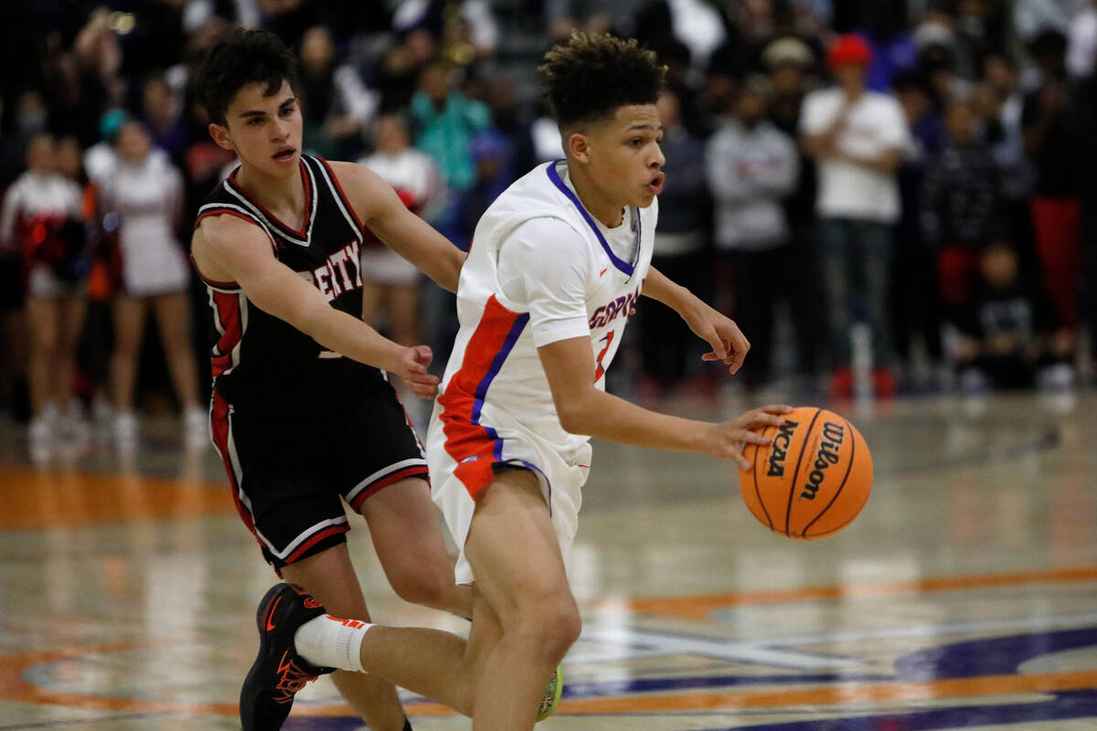 Bishop Gorman High School's John Mobley Jr. (3), right, drives past Liberty High School's Kaede ...