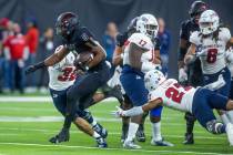 UNLV Rebels running back Aidan Robbins (9) leaps from a tackle attempt by Fresno State Bulldogs ...