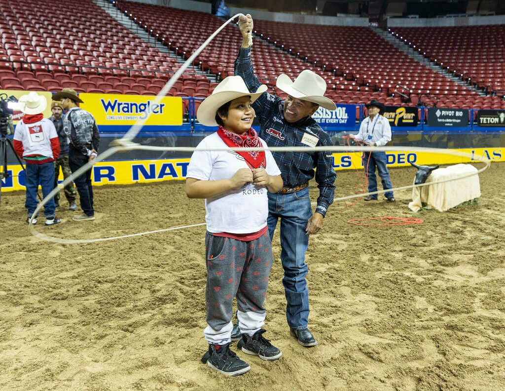 Participant George Macias, 10, has a lasso twirled about him by trick and fancy roper Thomas Ga ...