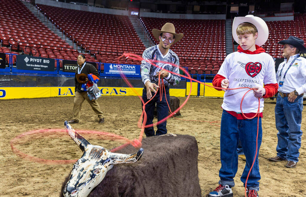 Participant Gavin Jones, 16, right, and bullfighter Redo toss ropes at a steer during the 38th ...