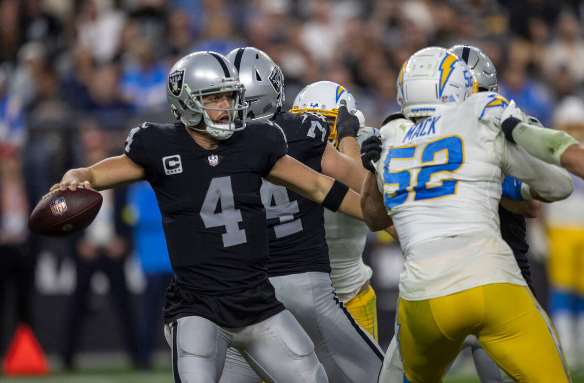 Raiders quarterback Derek Carr (4) looks to avoid pressure from Los Angeles Chargers linebacker ...