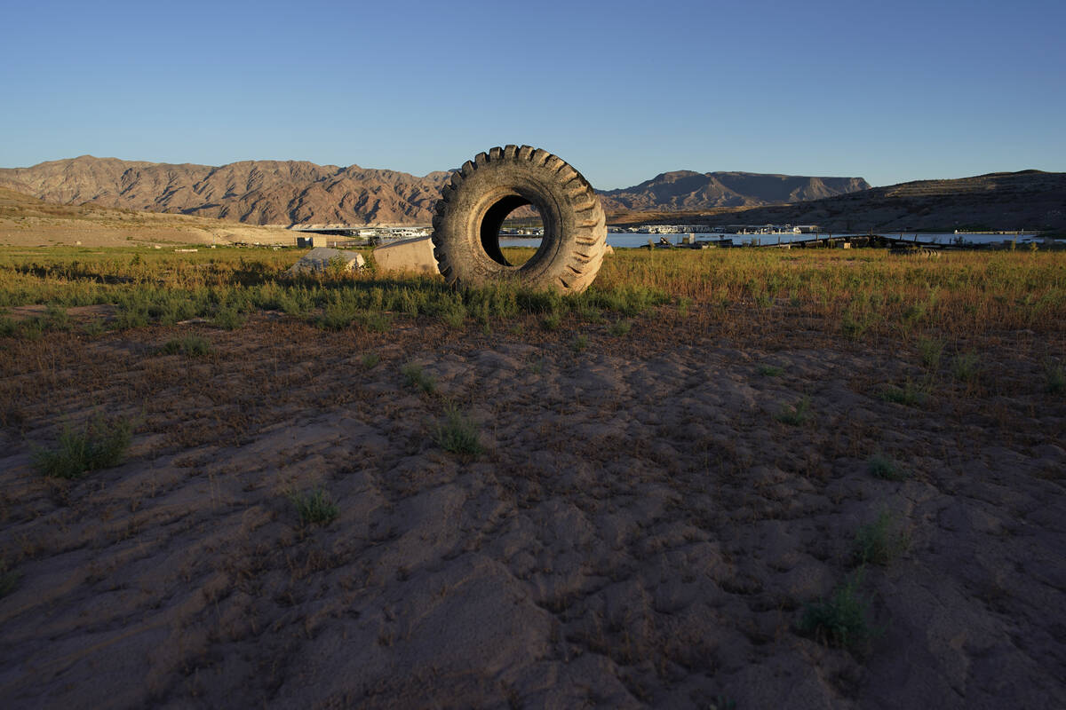 A truck tire once in the water as part of a marina sits on dry ground as water levels have drop ...