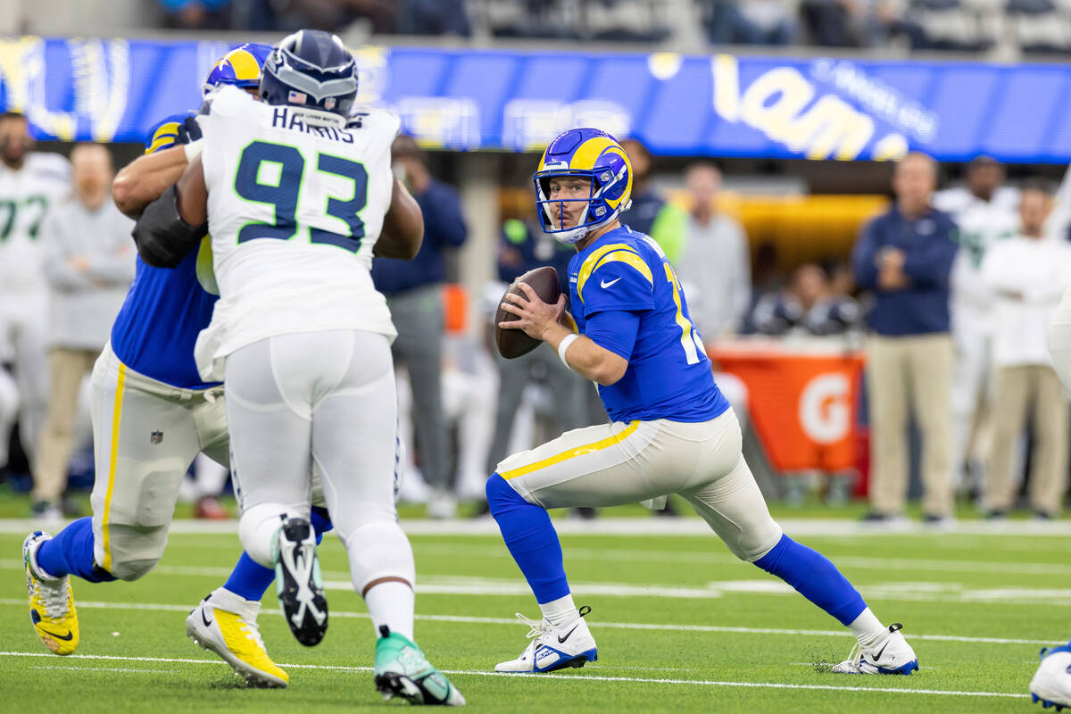 Los Angeles Rams quarterback John Wolford (13) rolls out to pass against the Seattle Seahawks i ...