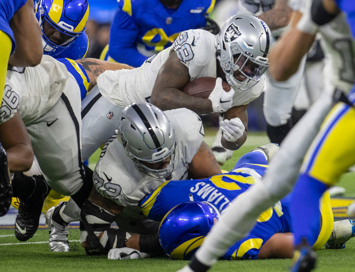 Raiders running back Josh Jacobs (28) is tackled during the first half of an NFL game against t ...