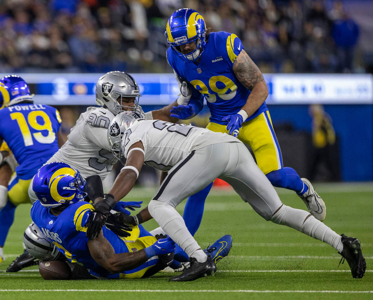 Raiders cornerback Sam Webb (27) and defensive tackle Jerry Tillery (90) look to make a recover ...