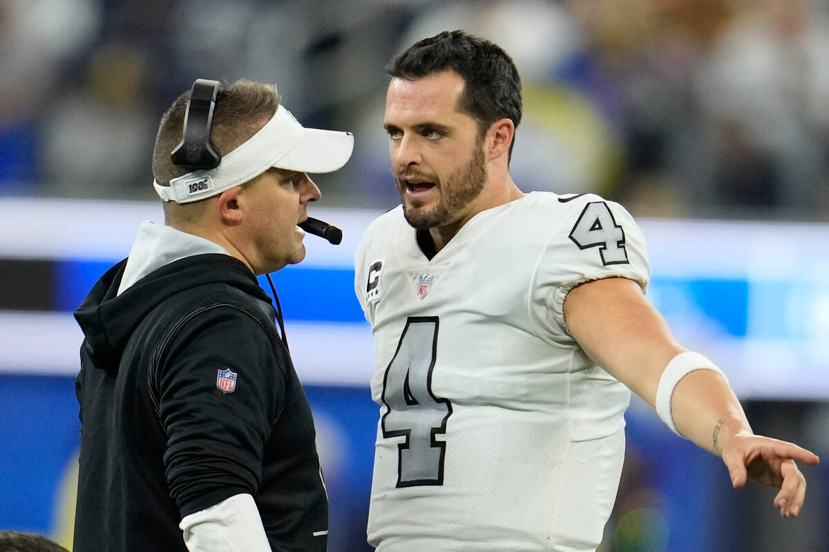 Las Vegas Raiders head coach Josh McDaniels, left, talks with quarterback Derek Carr during the ...