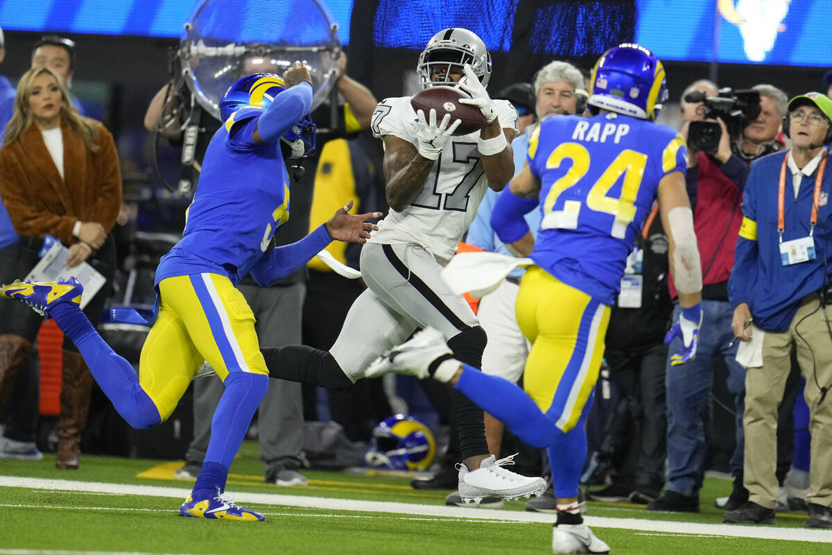 Las Vegas Raiders wide receiver Davante Adams, center, makes a catch as Los Angeles Rams corner ...