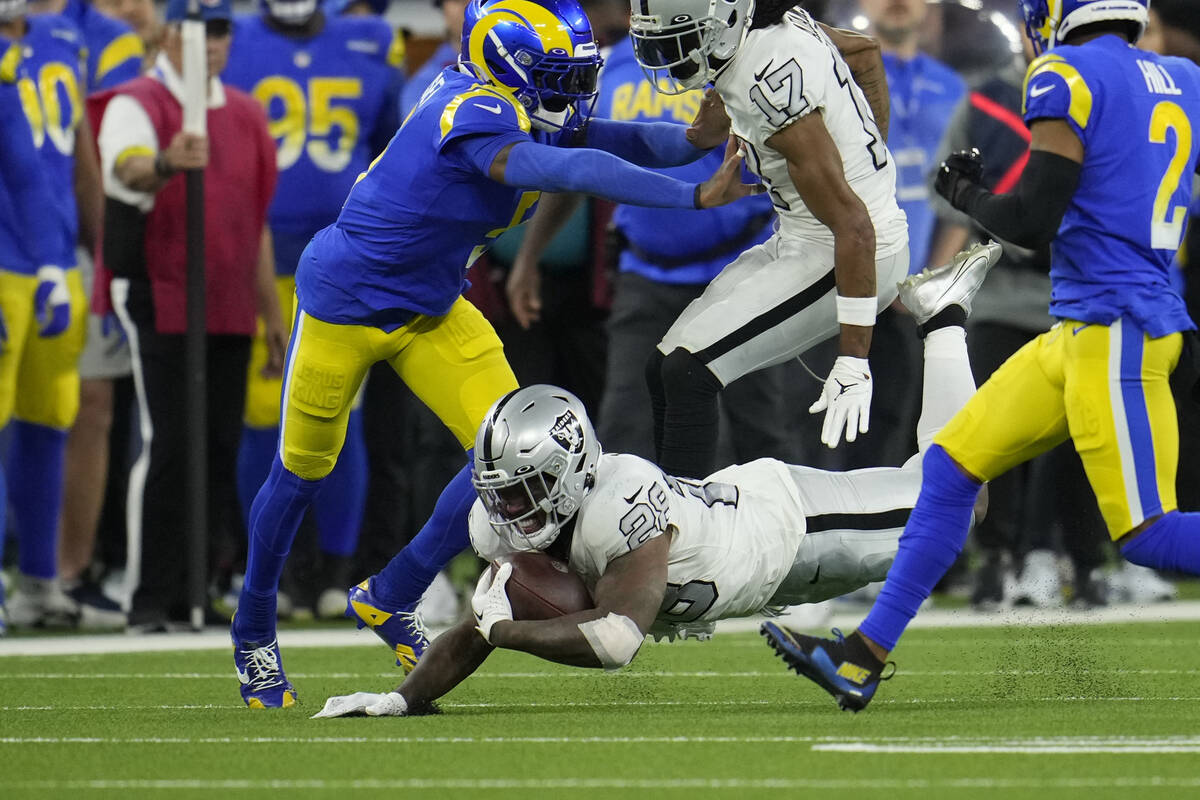 Las Vegas Raiders running back Josh Jacobs, below, dives forward with the ball during the secon ...