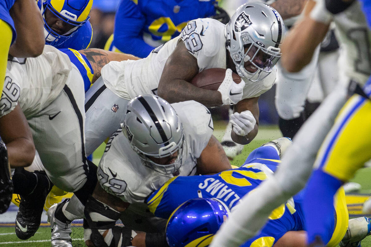 Raiders running back Josh Jacobs (28) is tackled during the first half of an NFL game against t ...