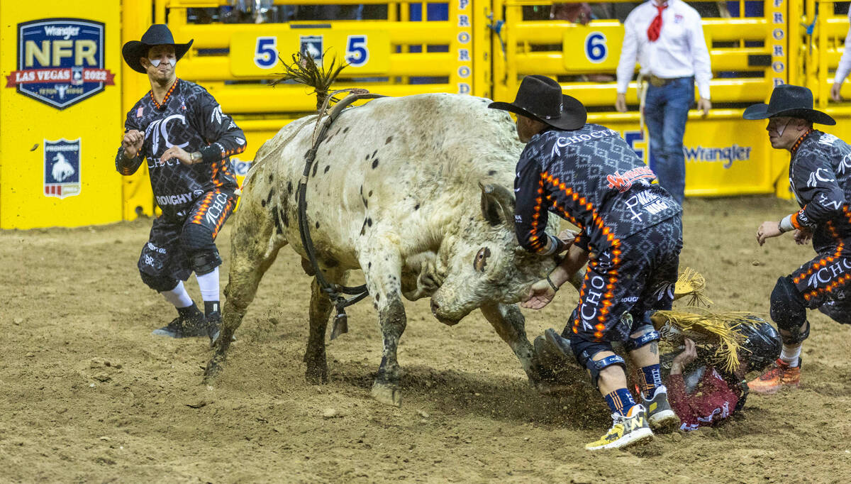 Bullfighter engage a bull to protect rider Trevor Kastner of Roff, OK., down on the dirt in Bul ...