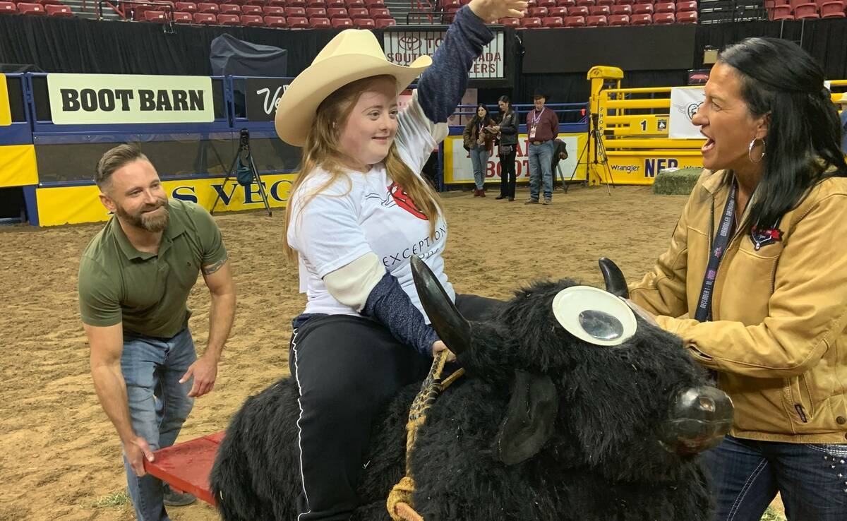 Hannah Huse is all smiles aboard the seesaw bull at Thursday morning's Exceptional Rodeo, held ...