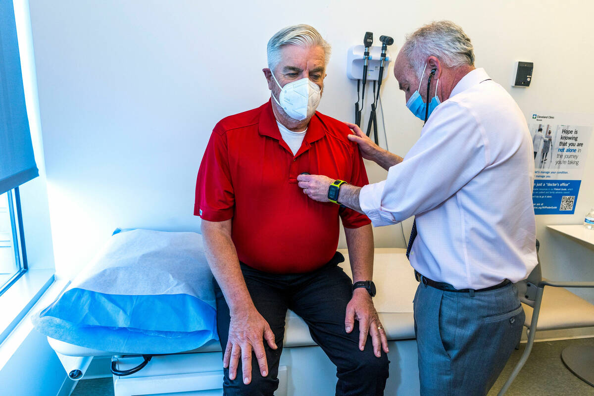 Dr. Charles Bernick, right, checks the heart of clinical trial participant Bob Lathrop before h ...